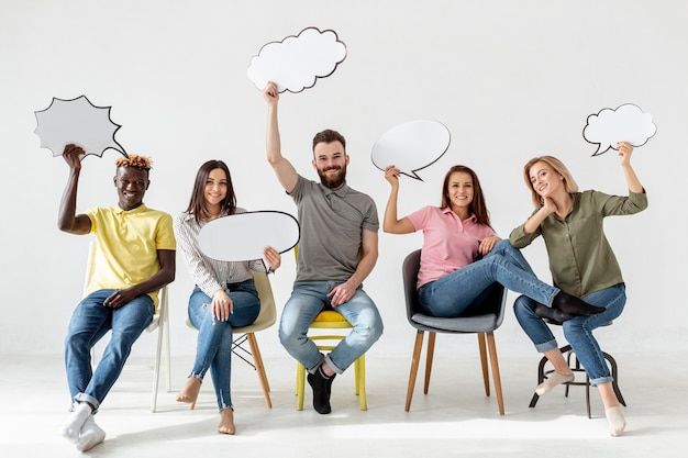 Low angle friends on chairs with chat bubbles